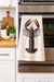 Lobster print kitchen towel hanging on oven in modern kitchen setting