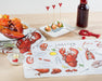 Lobster kitchen towel displayed on dining table with seafood and utensils