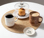 Tan Love You a Latte mug styled with coffee, dessert and an ivory quote mug