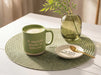 Green Matcha Made in Heaven mug styled with a coaster on a dining table