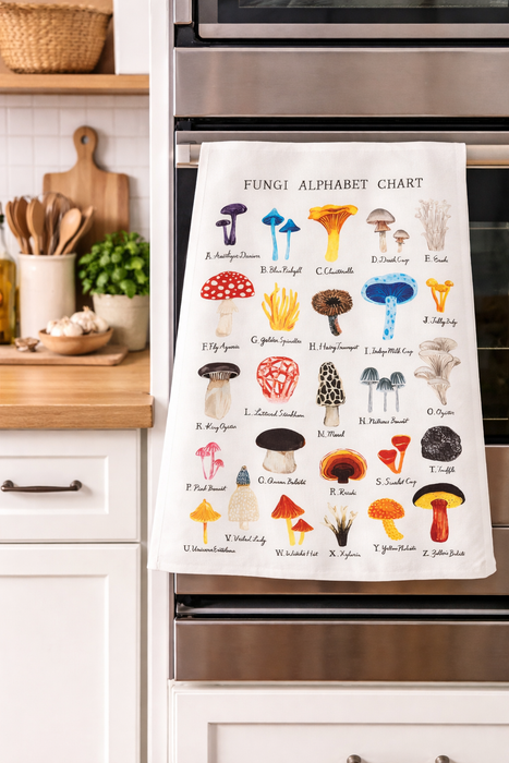Mushroom alphabet kitchen towel hanging on oven in modern kitchen with colorful botanical mushroom illustrations