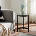 Renwil Avila black glass accent table styled beside a modern lounge chair