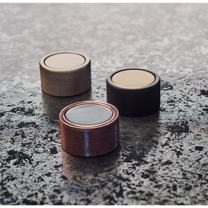 Richelieu 2065 cabinet knob collection shown in multiple finishes on stone surface