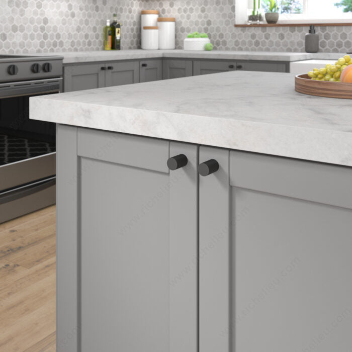 Richelieu 3060 matte black cabinet knobs installed on grey kitchen cabinetry