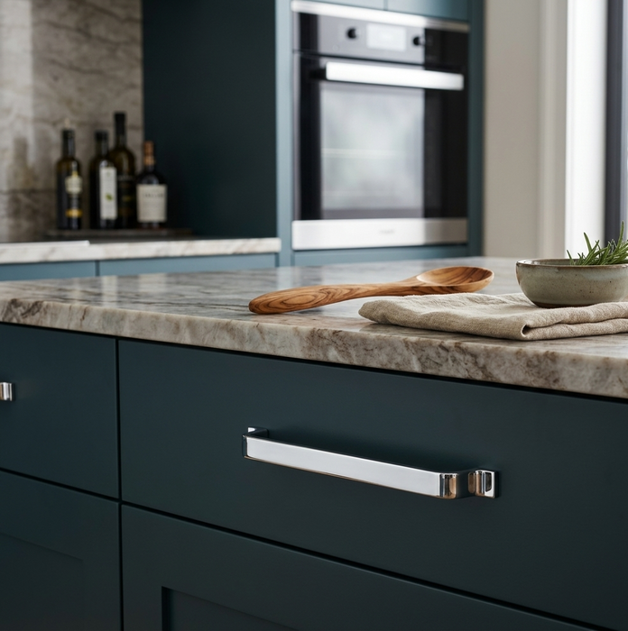 Richelieu 52003 modern metal cabinet pull in chrome installed on a dark teal cabinet