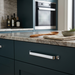 Richelieu 52003 modern metal cabinet pull in chrome installed on a dark teal cabinet