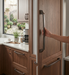 Richelieu 765 transitional appliance pull in brushed oil-rubbed bronze installed on panelled kitchen appliance