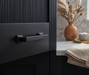 Richelieu 8645 transitional metal cabinet pull in matte black installed on a dark cabinet