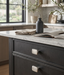 Richelieu 8655 brushed nickel cabinet knobs installed on dark wood dresser drawers