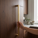 Richelieu 8655 modern metal appliance pull in brushed aurum gold installed vertically on a warm wood kitchen cabinet panel