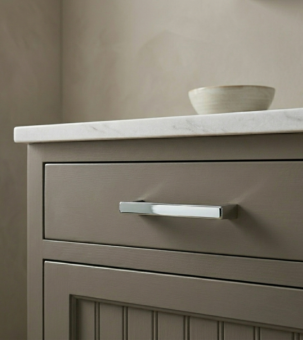 Richelieu 8655 modern metal pull in chrome installed on a taupe cabinet drawer