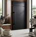 Richelieu 8695 transitional metal appliance pull in matte black installed vertically on a dark paneled refrigerator
