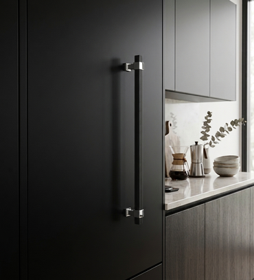 Richelieu 8747 modern fluted appliance pull in matte black and chrome installed vertically on a dark kitchen cabinet panel