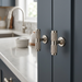 Richelieu 8997 polished gold cabinet knobs installed on a blue vanity cabinet