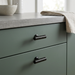 Richelieu 9208 spiral cabinet knob set of 2 in black finish installed on green kitchen cabinet