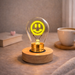 Smiley face neon LED light bulb on wooden base glowing in cozy room setting