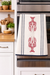 Striped lobster kitchen towel hanging on oven in modern kitchen with coastal design