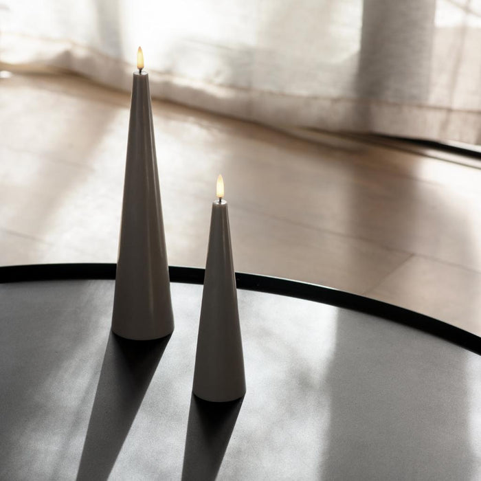 Uyuni sandstone flameless cone candle on a modern black table with soft ambient lighting
