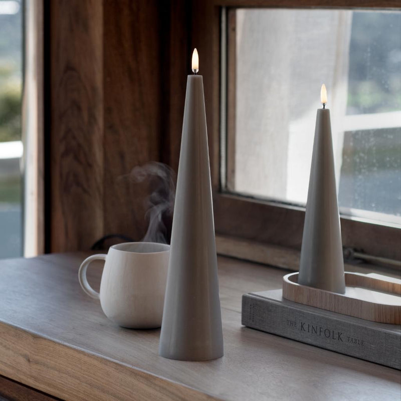 Uyuni LED flameless cone candle set in sandstone finish with realistic 3D flame placed on a wooden windowsill