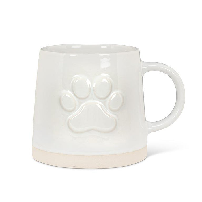 White stoneware mug with raised paw print design and wide natural-toned base